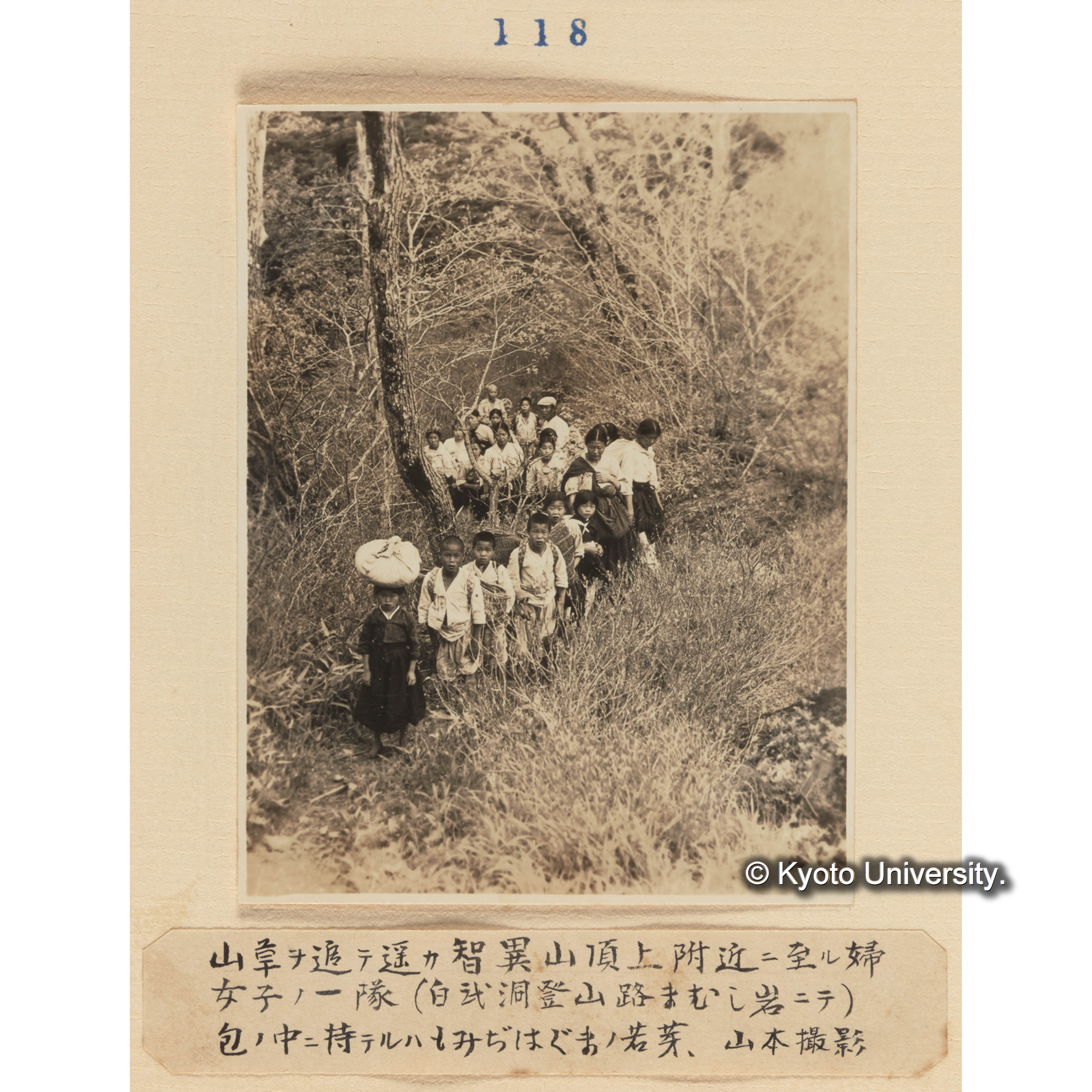 山草を追って遥か智異山頂上附近に至る婦女子の一隊（白武洞登山路マムシ岩にて）包の中に持てるはモミジハグマの若芽／山本撮影 (1)