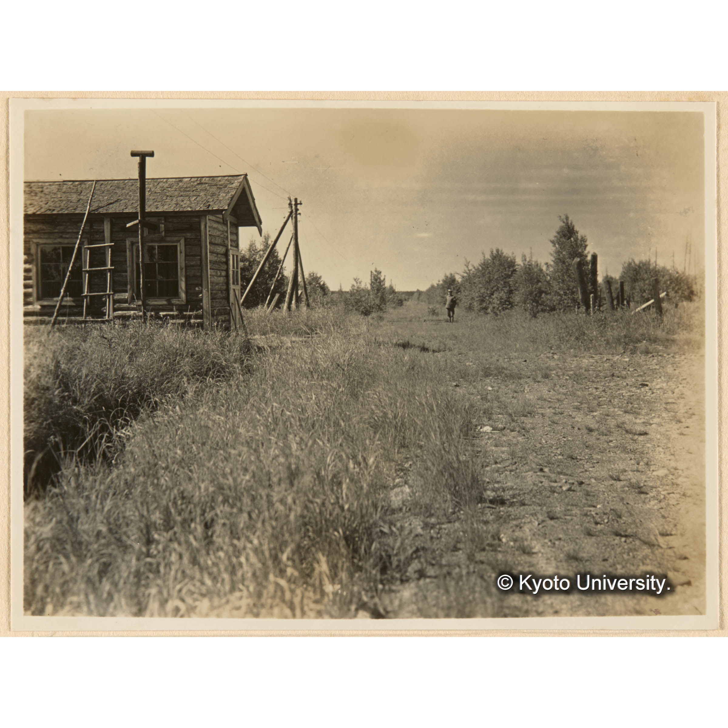 國境附近ノ景觀　人ノ立テル奌ヨリ左、右線ガ國境即チ人ノ背後ガ露領　小屋ハ冬季ニ於ケル日露郵便物交換所 (1)