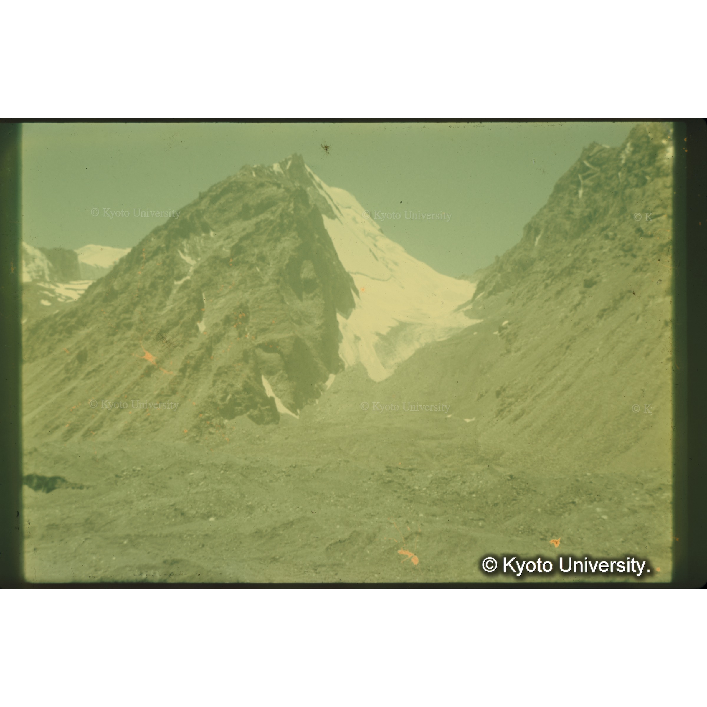 高度約3700m以上の氷河表面は黒い粘板岩の堆石がおおっている (1)