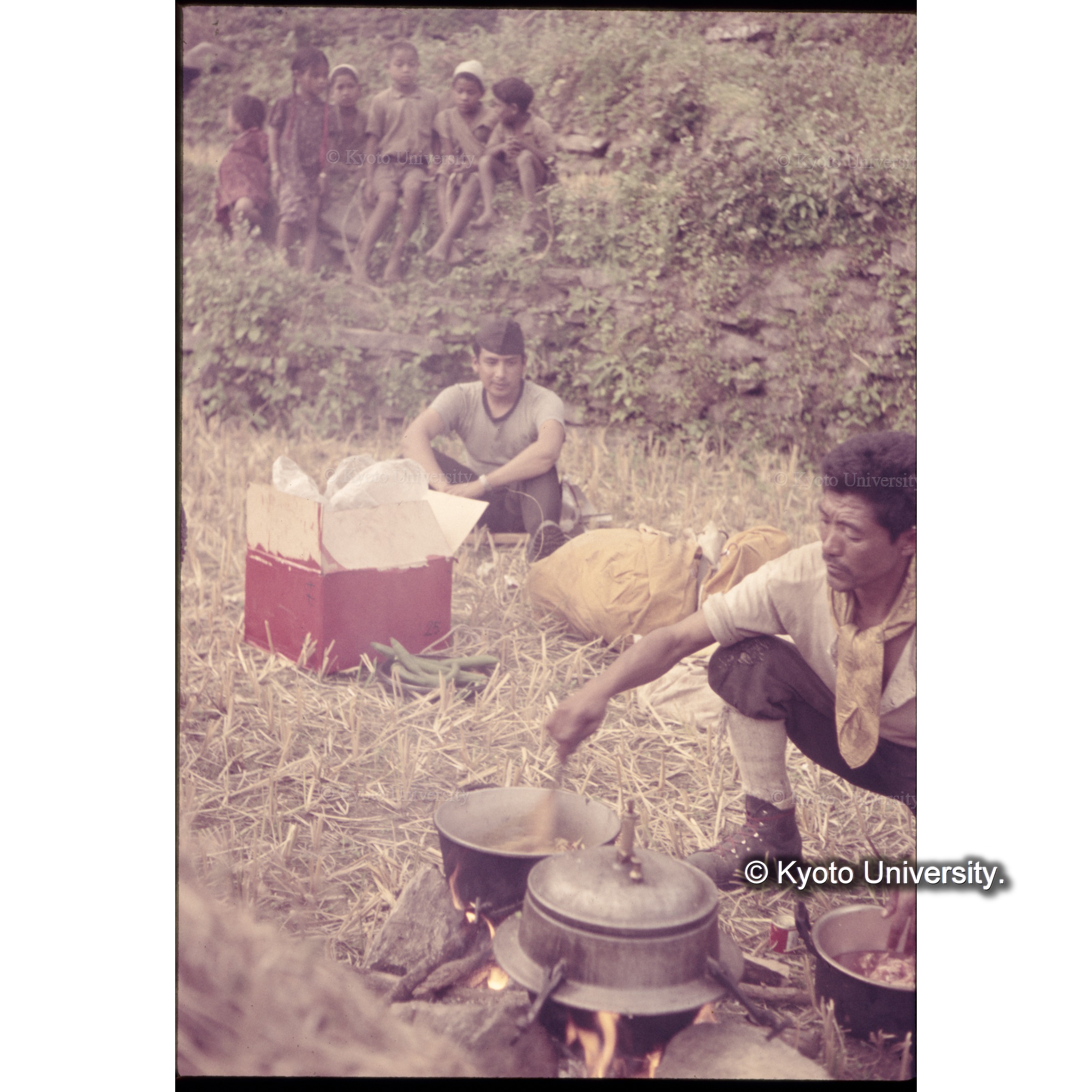 キャンプ地で調理するラクパ・ツェリン。連絡将校ラナが見ている (1)