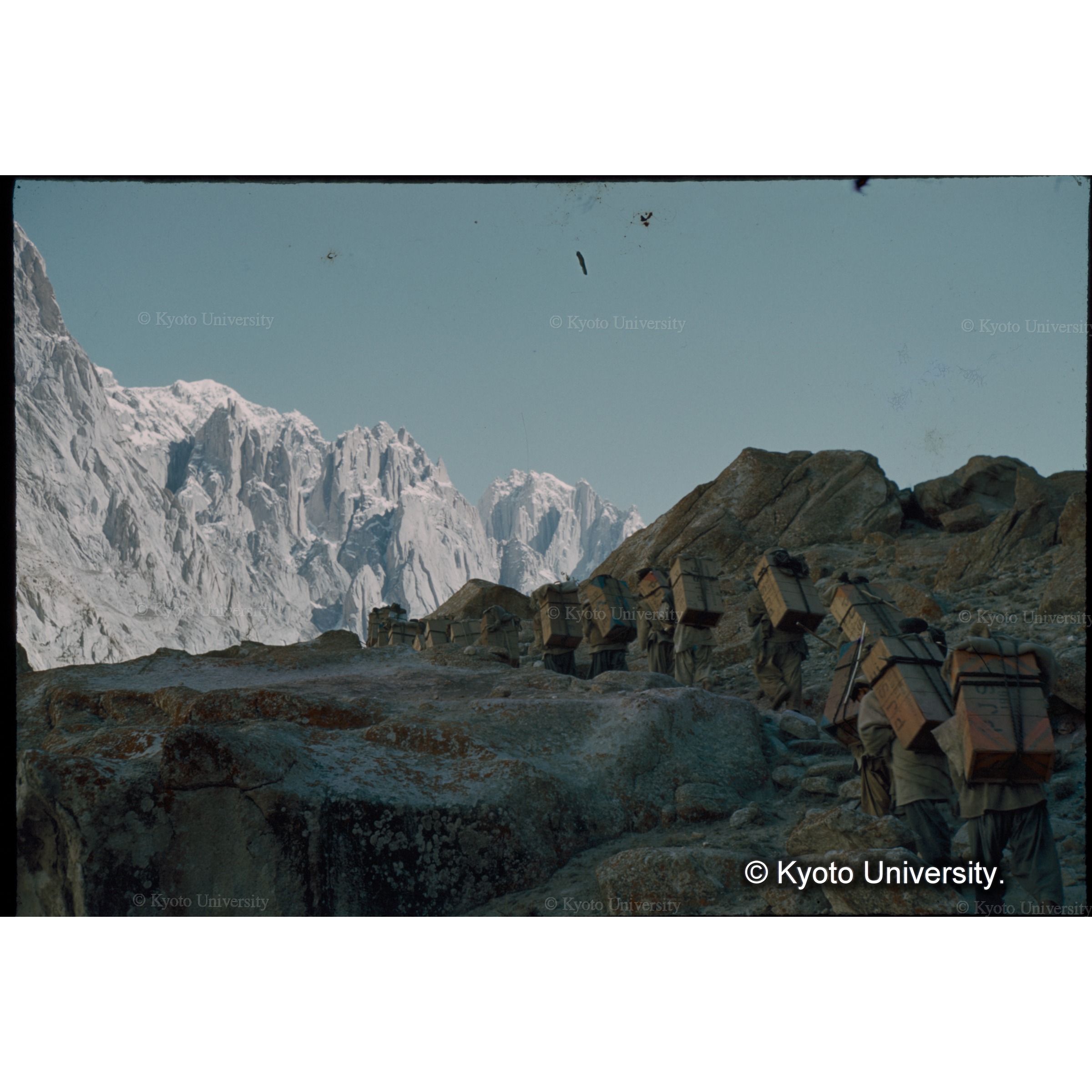 ギャリをあとに、氷河のモレーンを行くポーターたち (1)